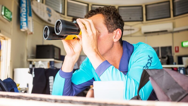 Lifeguard looks through the binoculars – Bild: Warner Bros. Discovery