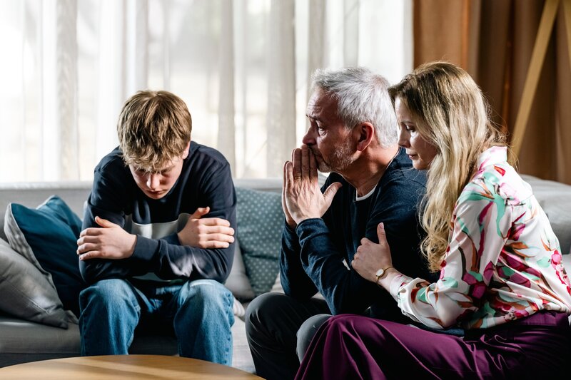 Nachdem die Studentin Sophie Rechberg ermordet wurde, kämpfen ihr Vater Johannes Rechberg (Thomas Dannemann, M.), ihre Stiefmutter Yolanda Rechberg (Pia Sarpei, r.) und ihr Bruder Toto Rechberg (Ted Trube, l.) mit den Tränen. Hängt der Tod mit Sophies kürzlich verstorbenen Mutter zusammen? – Bild: Martin Rottenkolber /​ ZDF