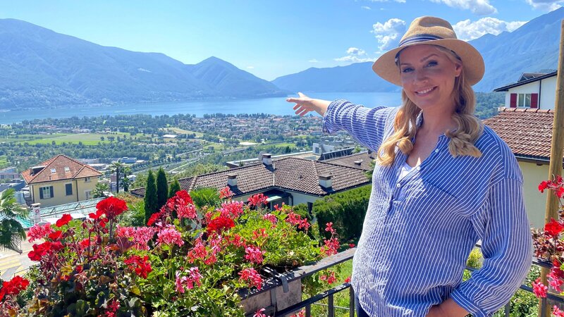 Judith Rakers auf Balkon vor dem Lago Maggiore. – Bild: ZDF und WDR/​Andreas Schlosser/​Bavaria Entertainment GmbH