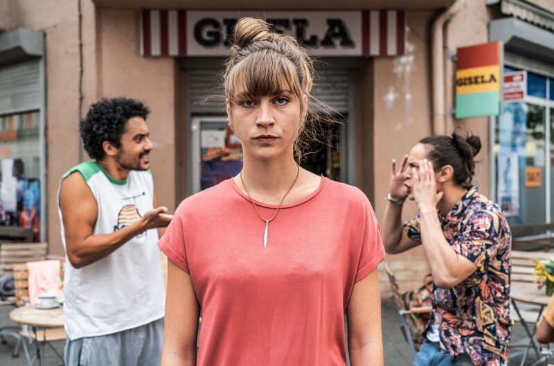 Sandra (Sophie Pfennigstorf, vorn) wird von ihren beiden Partnern Tom (Madieu Ulbrich, re.) und Jerome (Omar El – Saeidi, li.) mit ihrem Schwangerschaftstest konfrontiert. – Bild: MDR/Markus Nass Sandra (Sophie Pfennigstorf, vorn) wird von ihren beiden Partnern Tom (Madieu Ulbrich, re.) und Jerome (Omar El – Saeidi, li.) mit ihrem Schwangerschaftstest konfrontiert. – Bild: MDR/Markus Nass