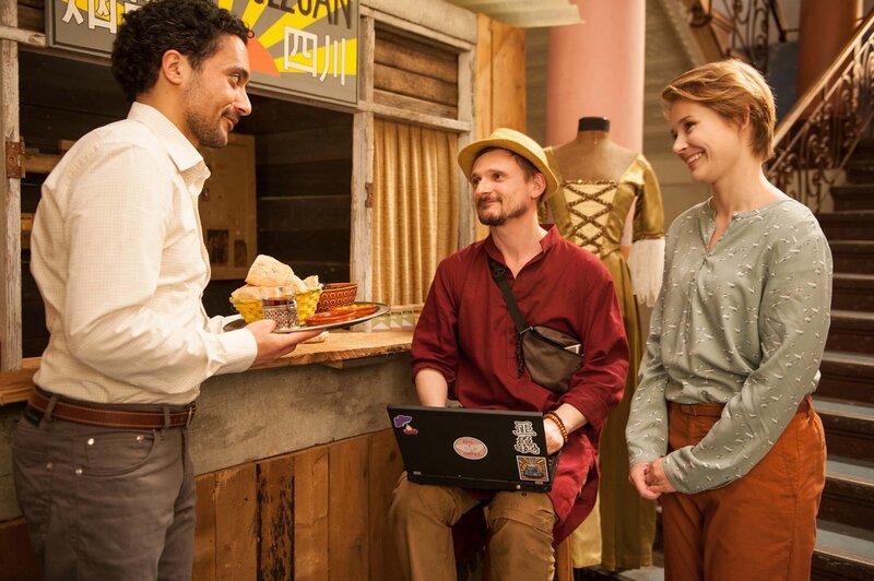 Jördis (Nadja Bobyleva, rechts) ist mit dabei als Haschim (Omar El-Saeidi, links) Alexej (Florian Lukas) gastfreundlich willkommen heißt. – Bild: BR/​Novafilm/​Alva Nowak