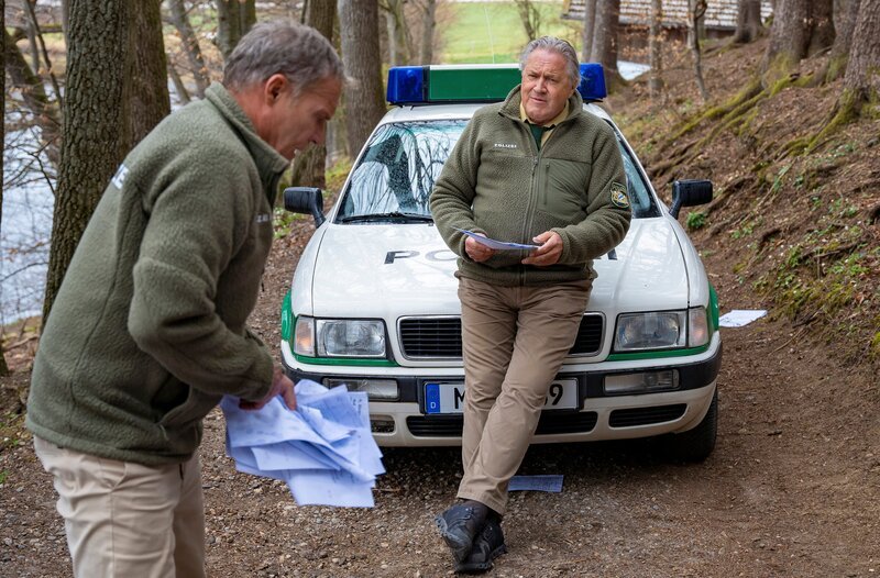 Hubert (Christian Tramitz, links) und Girwidz (Michael Brandner, rechts) sind im Streifenwagen unterwegs, als ihnen plötzlich etwas gegen die Windschutzscheibe fliegt. Das unbekannte Flugobjekt ist eine Matheklausur. – Bild: ARD/​Thomas Neumeier