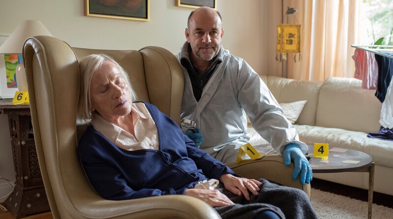 Die pflegebedürftige Witwe Edith Ruff (Heide Simon, l.) ist tot. Wurde die Rentnerin vergiftet? Dr. Strahl (Christoph Tomanek, r.) macht sich einen ersten Eindruck. – Bild: ARD/​Thorsten Jander