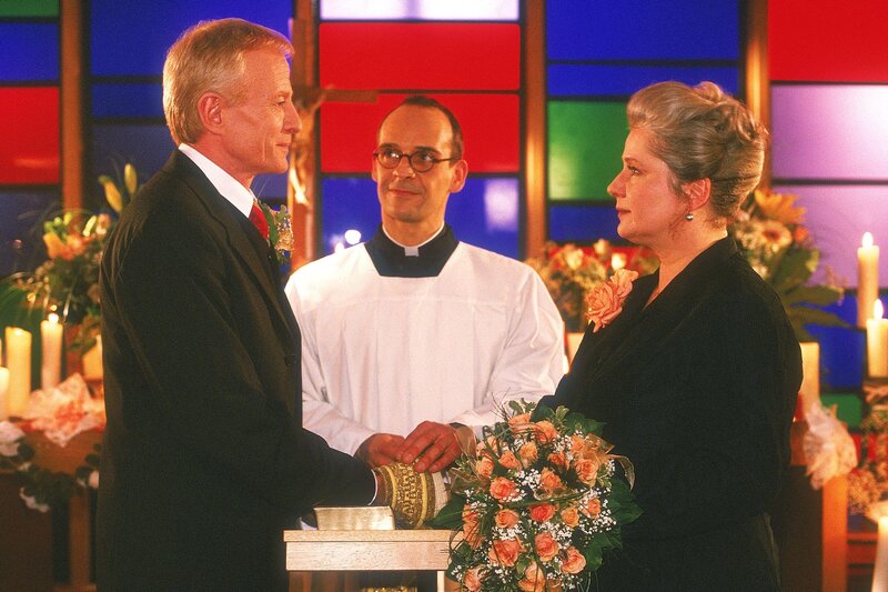 Dr. Lorenz Strauss (Rainer Goernemann, li.) und Uschi (Barbara Freier) geben sich vor Pater Groth (Peter Beck) das Ja-Wort. – Bild: RTL