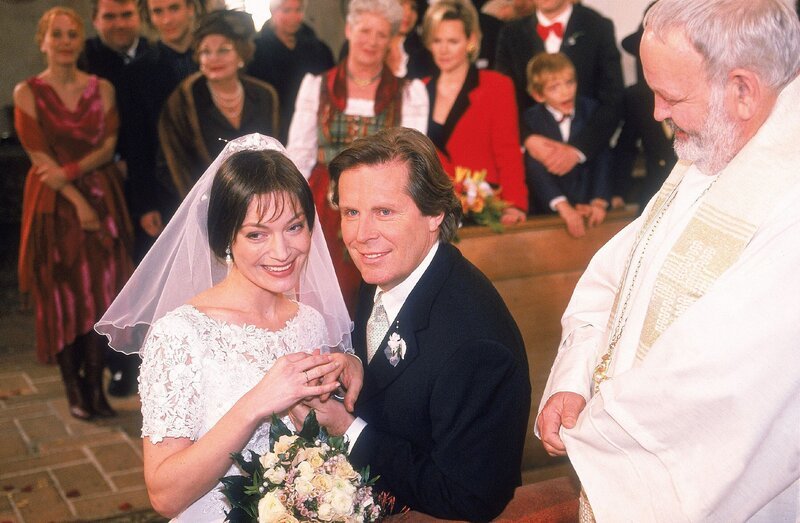 Das überglückliche Brautpaar, Sophie (Marion Mitterhammer) und Stefan (Sigmar Solbach), gibt sich vor dem Pfarrer (Michael Habeck) das Ja-Wort. – Bild: Mediengruppe RTL /​ RTLplus