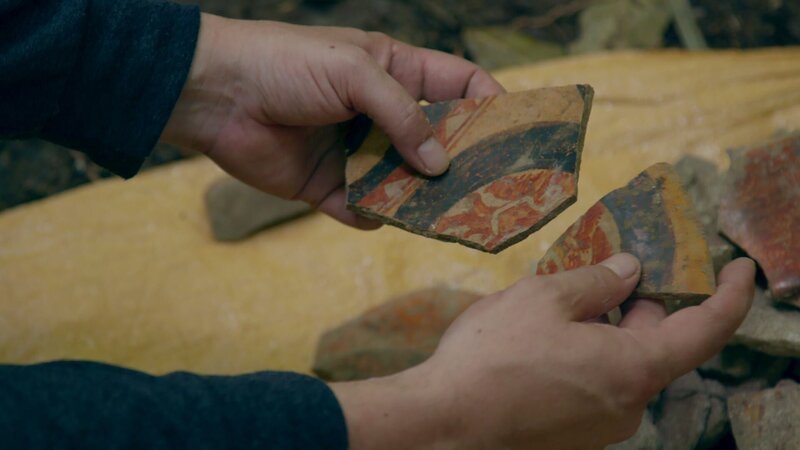 Der Archäologe Damien Marken hält Scherben einer vielfarbigen Keramik, die in El Peru gefunden wurde (National Geographic). – Bild: National Geographic