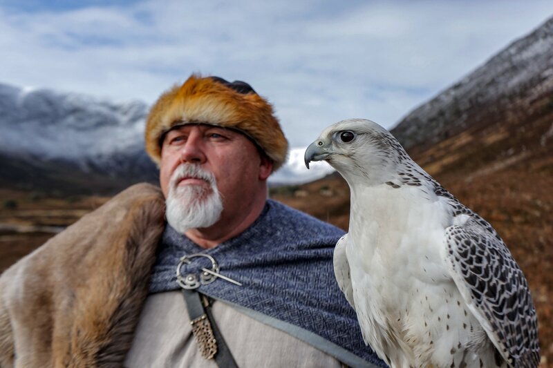 Ein Reenactor-Wikinger und ein Gerfalke (Gyrfalcon) in der verschneiten Landschaft des Alladale Naturschutzgebietes in Schottland. – Bild: 3sat