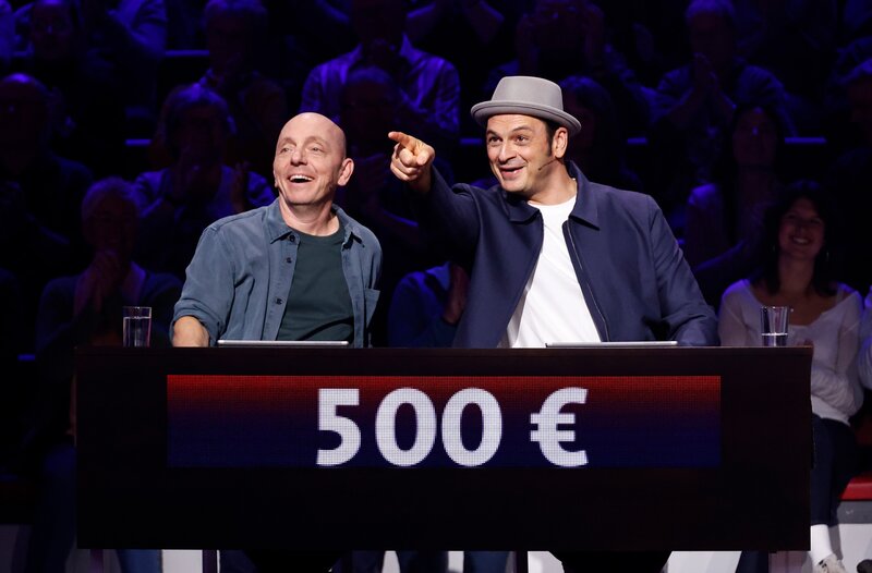 Rateteam-Kapitän Bernhard Hoëcker (l.) mit Komiker, Fernsehmoderator, Schauspieler und Livestreamer Kaya Yanar (r.). – Bild: ARD/​NDR/​Morris Mac Matzen