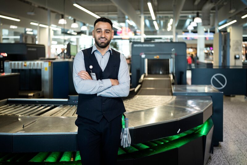 Ahmed El-Dannaoui posiert für ein Porträt am Flughafen Melbourne. – Bild: ITV Studios/​Kelly Gardner