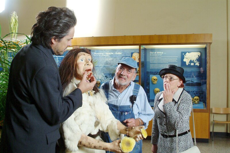 Tante Anna (Annemone Haase, r.) schaut verärgert. Trägt die Neandertalerin etwa ihre Zähne? Peter (Peter Lustig 2.v.r,) und der Anthropologe (Matthias Diem, l.) können sich das nicht erklären. – Bild: ZDF/​Christiane Pausch