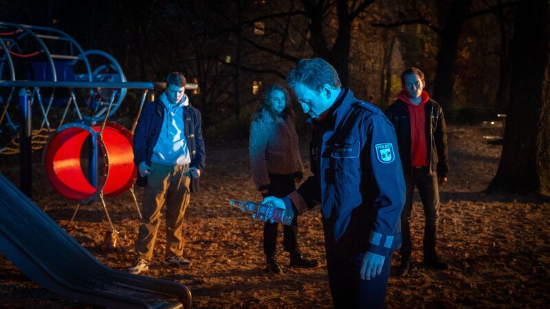 Auf einem Spielplatz stören Violetta (Amelie Herres, 2. v. l.), Marek (Alvar Goetze, r.) und Simon (Elmo Anton Stratz, l.) lautstark die Nachtruhe der Nachbarn. Timmermann (Mathias Junge, 2. v. r.) schickt die aufgedrehten Jugendlichen nach Hause. Doch am nächsten Morgen ist einer von ihnen tot. – Bild: ZDF und Marc Meyerbröker