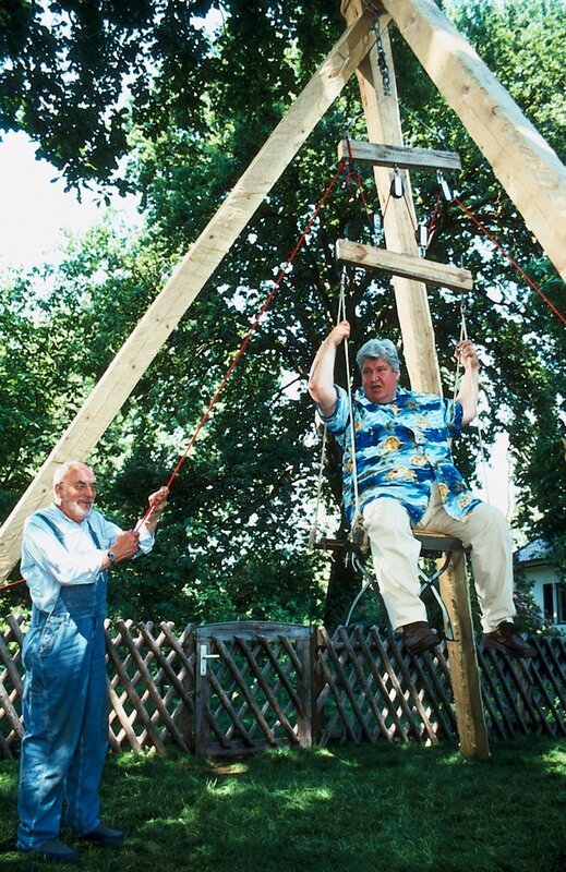 Peter (Peter Lustig, l.) hat einen Flaschenzug konstruiert. Sein kräftig gebauter Nachbar Paschulke (Helmut Krauss, r.) dient ihm als Testobjekt. – Bild: ZDF