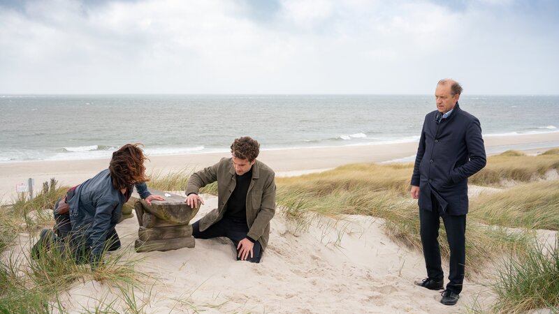Carl Sievers (Peter Heinrich Brix, r.) findet in den Unterlagen der toten Hebamme Silke Adler einen versteckten Zettel mit einer verschlüsselten Information. Ina Behrendsen (Julia Brendler), Hinnerk Feldmann (Oliver Wnuk, M.) und Carl Sievers müssen das Rätsel um diese geheime Botschaft lösen, um den Fall aufzuklären. – Bild: ZDF und Georges Pauly