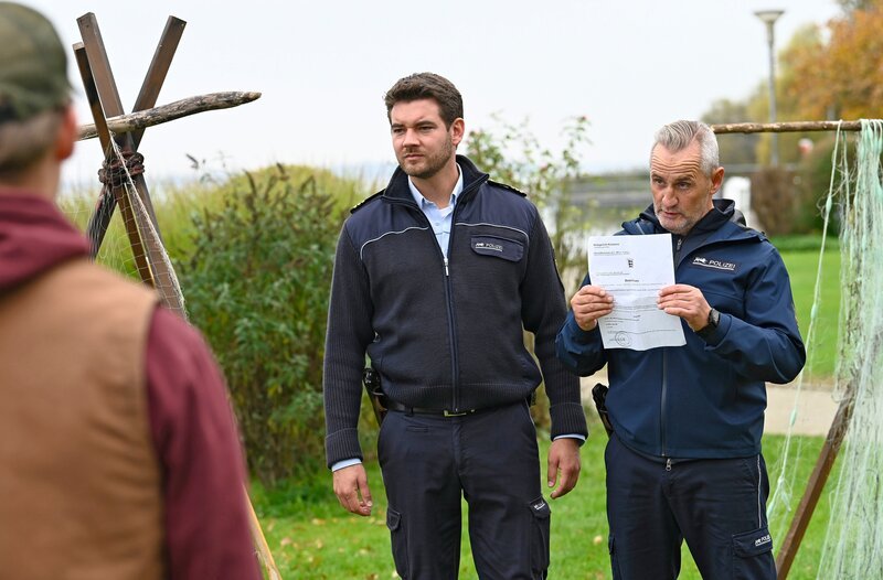 Jakob (Max König, M.) und Paul (Tim Wilde, r.) statten den Wennings (Nico Liersch, l.) mit einem Durchsuchungsbeschluss einen Besuch ab. – Bild: ARD/​Laurent Trümper