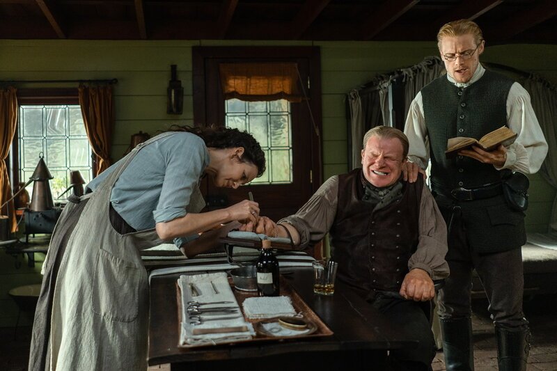 Outlander Staffel 6 Folge 3 Caitriona Balfe als Claire Randall, Mark Lewis Jones als Tom Christie, Sam Heughan als Jamie Fraser – Bild: SRF/​2022 Sony Pictures Television Inc.