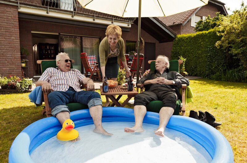 Die Füße im Planschbecken – Günter Hoffmann (Peter Lerchbaumer, li.) und Edwin Bremer (Tilo Prückner, re.) genießen den Sommer und lassen sich von Heidrun (Verena Plangger, mi.) verwöhnen. – Bild: ARD/​Kai Schulz