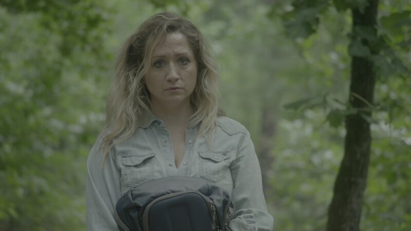 A woman holding a backpack, looking worried. – Bild: Discovery Communications