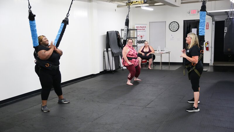 L-R: Ashley and Tina learn how to do a bungee workout as Vannessa watches. – Bild: Discovery Communications, LLC/​Gabrielle Kuse
