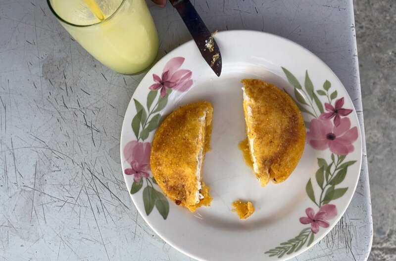 Die kolumbianische Spezialität Arepas: Der Fladen aus Maispaste wird mit Rinderhack und Ei gefüllt und anschließend kurz frittiert. – Bild: Elephant Doc