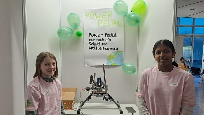 Die 14-jährigen Olivia (links) und Sana (rechts) haben ein Tretpedal erfunden, mit dem sich im Unterricht Tablets und Handys aufladen lassen sollen. Mit ihrer Erfindung sind sie auch beim Wettbewerb ‚Jugend forscht‘ angetreten. – Bild: ZDF