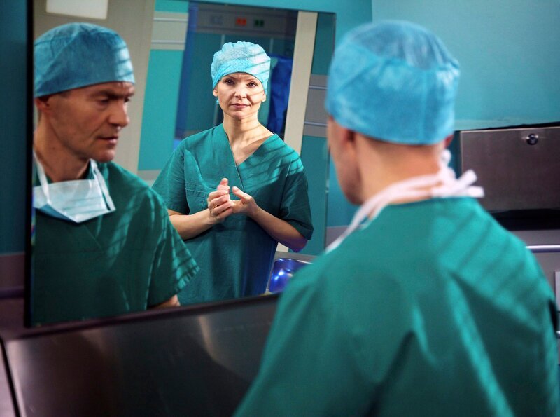 Dr. Kathrin Globisch (Andrea Kathrin Loewig) merkt, dass Dr. Kaminski (Udo Schenk) seit der Begegnung mit Martin an Elenas Krankenbett das Ärztezimmer meidet. Als Kathrin ihn bei einer gemeinsamen OP darauf anspricht, geht Kaminski aber nicht darauf ein – Dr. Globisch hätte da einen falschen Eindruck. – Bild: MDR/​Wernicke