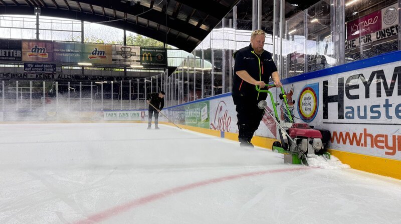 Feinarbeit an der Bande: Eismeister Julian und Niklas schaffen perfekte Bedingungen fürs Auftaktspiel. – Bild: NDR/​Stella Valerie Ulrich