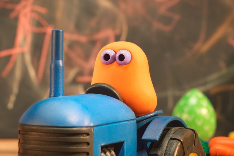 Guetnachtgschichtli - Die Mini Boings - Frücht und Buurehof; Staffel 2, Folge 2; Ein Mini Boing mit orangefarbenem Kopf sitzt auf einem blauen Spielzeugtraktor. – Bild: SRF/Aardman Guetnachtgschichtli - Die Mini Boings - Frücht und Buurehof; Staffel 2, Folge 2; Ein Mini Boing mit orangefarbenem Kopf sitzt auf einem blauen Spielzeugtraktor. – Bild: SRF/Aardman