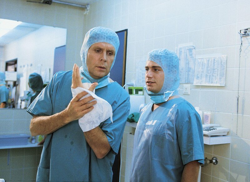 Dr. Stefan Frank (Sigmar Solbach, li.) und Assistenzarzt Dr. Peter Stein (Zacharias Preen) haben gerade die Schusswunde von Fredi operiert. – Bild: RTL Passion