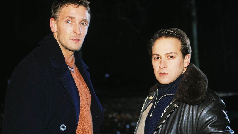 André (Mark Keller, li.) und Semir (Erdogan Atalay) treffen am Unfallort ein und stellen fest, dass der Mann aus dem brennenden Auto auf dem Fahrersitz erschossen wurde. – Bild: TVNOW