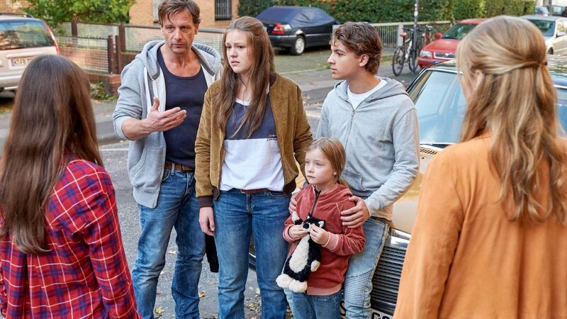 Stefan Vollmer (Hendrik Duryn, 2.v.l.) möchte, dass Iris (Birthe Wolter, l.) Xenia (Merle Juschka, 3.v.l.) und ihren Geschwistern Yves (Oskar Redfern) und Zazie (Julia Völk) hilft. r.: Karin (Jessica Ginkel) – Bild: TVNOW /​ Frank Dicks