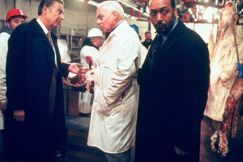 Die Detectives Briscoe (Jerry Orbach, li.) und Green (Jesse L. Martin, re.) ermitteln im Mordfall eines erstochenen Tierschützers, der verunreinigtem Fleisch in Hamburgern auf der Spur war, die zu der Firma „Elite-Fleischwaren“ führte. Dort sprechen sie mit dem Eigentümer des Betriebes, Arthur King (Jesse Doran). – Bild: RTL