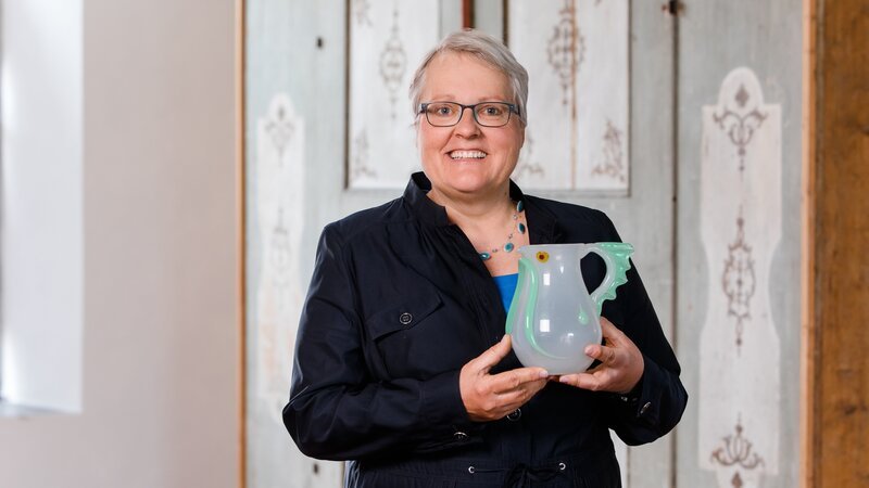 Die Glaskaraffe aus der Wassermannserie ist von der Glasmanufaktur Lötz in der Zeit um 1906. – Bild: BR/​Vera Johannsen