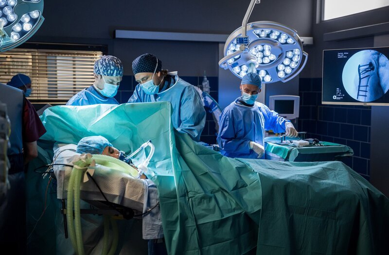 Dr. Mikko Rantala (Luan Gummich) und sein Kollege Florian Osterwald (Lion Wasczyk) operieren ihre Patientin Alina Carini (Hannah Gharib). (v.l.n.r.: Hannah Gharib (liegend), Lion Wasczyk, Luan Gummich) – Bild: ARD/​Michael Kremer