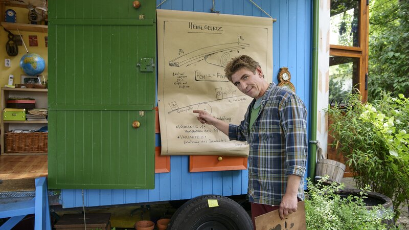 Wie riesig muss ein Hebel sein, um den Bauwagen anzuheben? Fritz Fuchs’ (Guido Hammesfahr) Erfindergeist ist gefragt. – Bild: ZDF/​Antje Dittmann