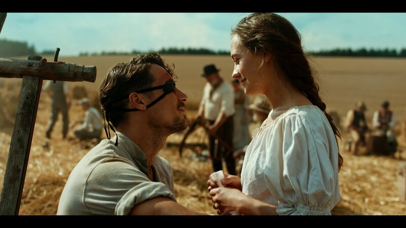 Clara Prank (Mercedes Müller) verarztet ihren Verlobten Roman Hoflinger (Klaus Steinbacher) nach dem Fingerhakeln am Rande der Weizenernte. – Bild: ARD Degeto/​BR/​MDR/​WDR/​Zeitsprung Pictures GmbH/​Felix Cramer