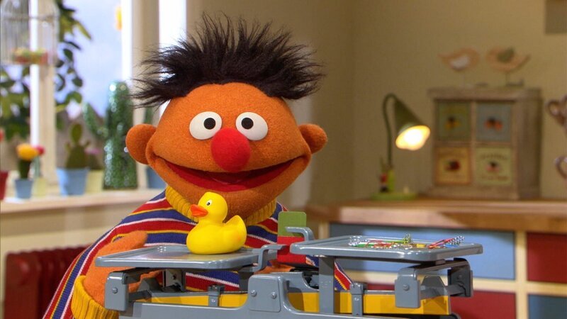 Ernie wiegt Quietscheentchen. – Bild: NDR/​Studio Hamburg Produktion/​Sesame workshop