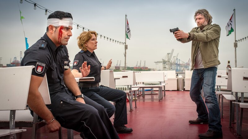 Malte (Jörg Witte, r.) hat Tarik (Serhat Cokgezen, l.) und Claudia (Janette Rauch, M.) in seiner Gewalt und verlangt von ihnen, dafür zu sorgen, dass er mit seinem Sohn sprechen kann. – Bild: ZDF