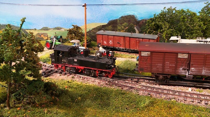 Die IVK macht sich von Naundorf aus mit ihrem Rollwagenzug in Richtung Oschatz auf den Weg. Im gedeckten Güterwagen ist Kaolin aus einem der Steinbrüche rund um Kemmlitz. Kaolin ist ein Rohstoff für die Porzellanherstellung. – Bild: SWR