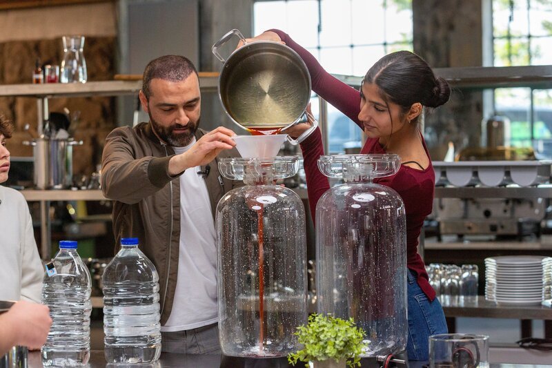 Sebastian Lege zeigt den Schülerinnen und Schülern der Katharina-Henoth-Gesamtschule in Köln wie man einen leckeren, selbstgemachten Eistee zubereitet. – Bild: ZDF/​Katja Inderka