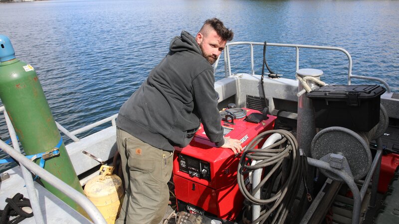 Don Gann posiert recht verführerisch mit seiner Tauchausrüstung in Brooklyn, NY. – Bild: Warner Bros. Discovery, Inc. or its subsidiaries and affiliates. All rights reserved.