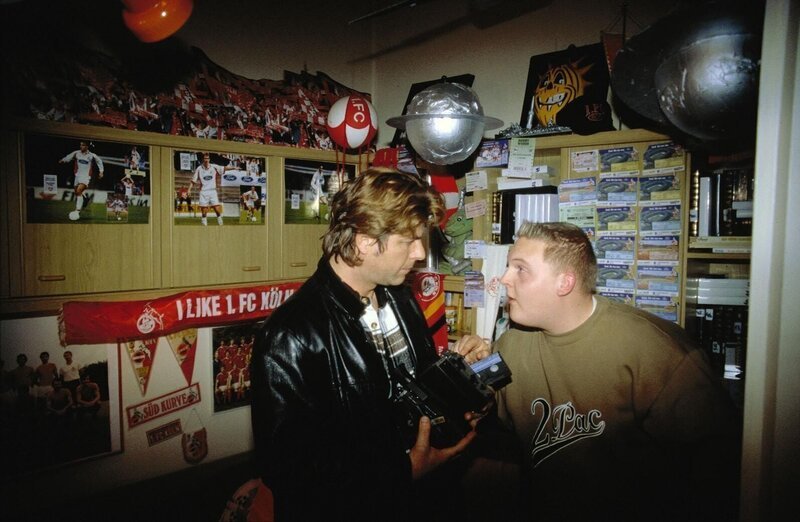 Jupp (Uwe Fellensiek, l.) unterhält sich mit Robbie (Axel Stein, r.) über das Spiel, das er auf Videokassette aufgezeichnet hat. – Bild: SAT.1 /​ Florian Müller Eigenproduktionsbild frei