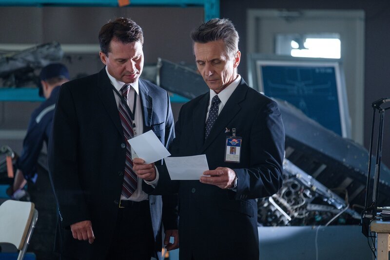 Ein russischer Ermittler (gespielt von Val Ovtcharov, rechts) studiert Luftaufnahmen der Absturzstelle von Aeroflot Nord Flug 821. – Bild: Cineflix /​ Darren Goldstein