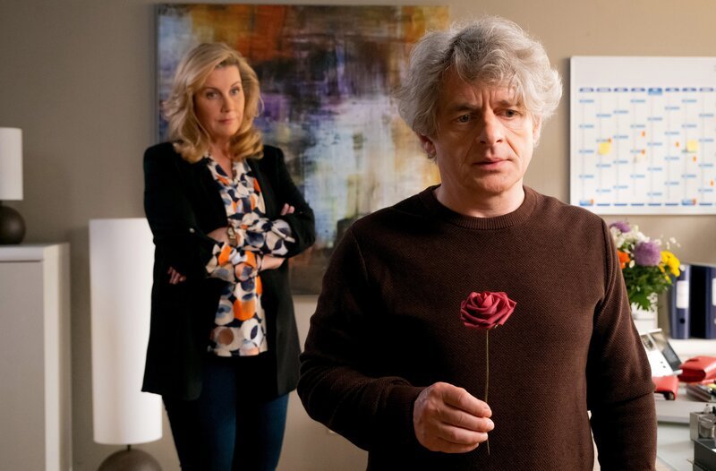 Bea Hölsch (Daniela Wutte, re.) ist mit Fieber umgekippt und hat sich einen Schlüsselbeinbruch zugezogen. Ihren behandelnden Arzt Dr. Martin Stein (Bernhard Bettermann, li.) bringt sie mit ihrem sehr anschmachtenden Verhalten in eine ziemlich unangenehme Situation. Auch Dr. Kathrin Globisch (Andrea Kathrin Loewig, mi.) ist ziemlich irritiert. – Bild: MDR/​Saxonia Media/​Sebastian Kiss