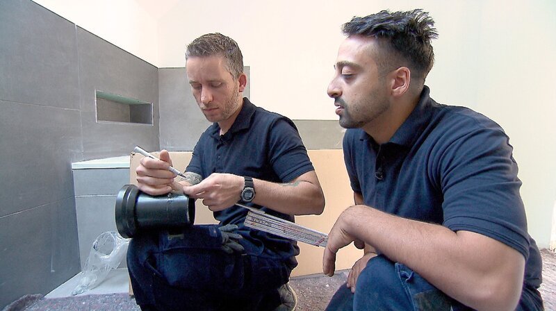 Sanitär-Heizung-Klimatechnik-Azubi Nick (36) wird von Geselle Hussain (33) bei der Installation einer Toilette getestet. – Bild: WDR/​Warner Bros. International Television Production Deutschland GmbH