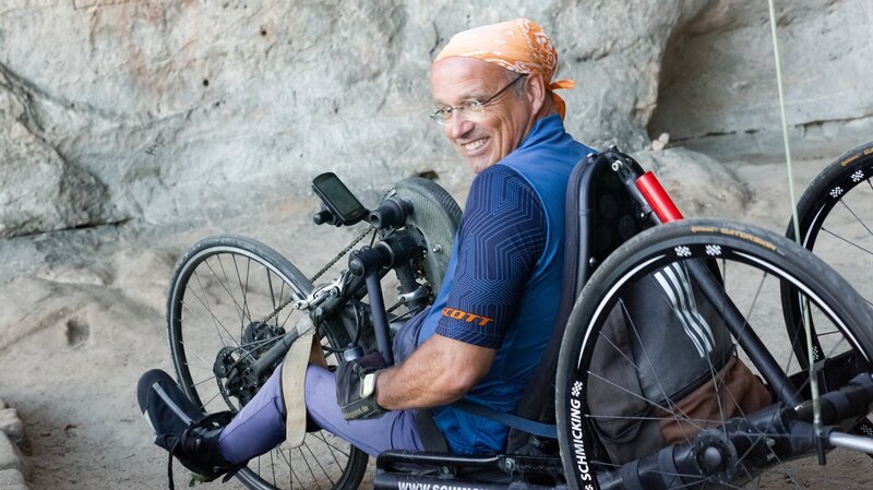 Veit Riffer (58) ist seit einem Kletterunfall vor knapp 30 Jahren querschnittsgelähmt. Heute erobert er seine „Felsenheimat“ Sächsische Schweiz mit dem Handbike und testet Handbike- und Rolliwanderstrecken für andere Rollstuhlfahrer. – Bild: ZDF und Angela Liebich