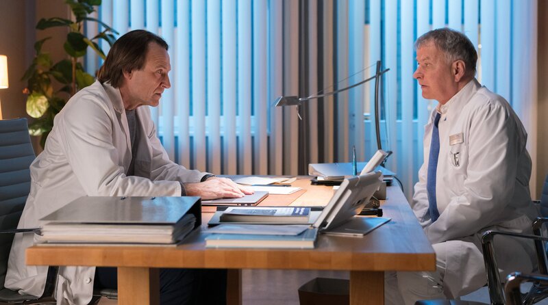 Dr. Roland Heilmann (Thomas Rühmann, re.) muss mit seinem Freund, dem Klinikleiter Dr. Martin Stein (Bernhard Bettermann, li.), reden. Martin geht es seit geraumer Zeit nicht so gut, doch nun lässt er seine Launen ungezügelt an seinen Mitarbeitern und Freunden aus. – Bild: MDR/​Rudolf Wernicke