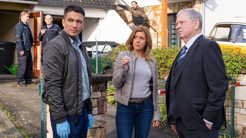 Die Kommissare Max Fischer (Max Hemmersdorfer, l.), Fiona Coors (Kerstin Klar) und Oberstaatsanwalt Bernd Reuther (Rainer Hunold, r.) finden im Garten des Opfers eine Zahnprothese. – Bild: ZDF und Andrea Enderlein