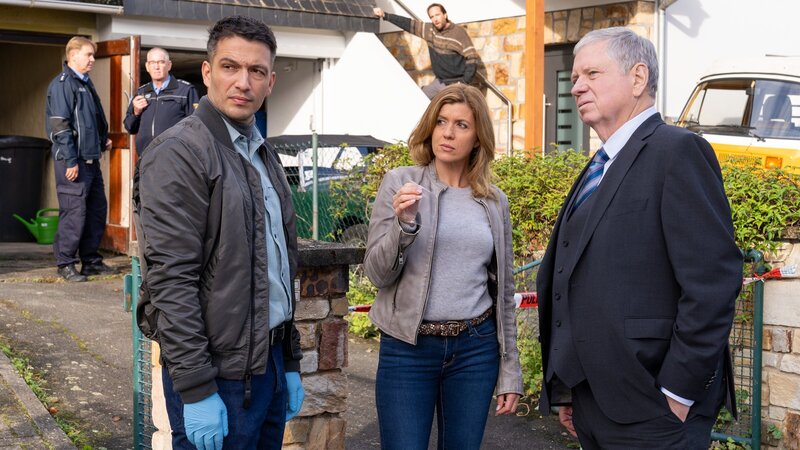 Die Kommissare Max Fischer (Max Hemmersdorfer, l.), Fiona Coors (Kerstin Klar) und Oberstaatsanwalt Bernd Reuther (Rainer Hunold, r.) finden im Garten des Opfers eine Zahnprothese. – Bild: ZDF und Andrea Enderlein