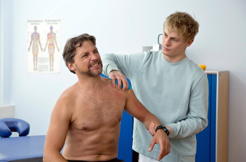 Piwis (Meo Wulf, r.) ehemaliger Fitnesstrainer Robert Feldmann (Patrick Bach, l.) ist wieder in Eisenach und wird Piwis erster Patient. – Bild: ARD/​Volker Roloff