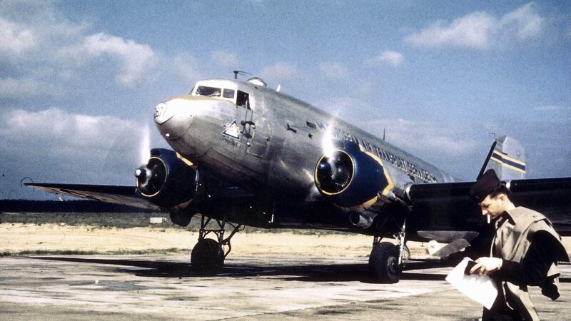 Fast zwölf Monate lang versorgten die Alliierten die Westsektoren Berlins ab Juni 1948 mit den berühmten „Rosinenbombern“ aus der Luft. Inzwischen konnte nachgewiesen werden, dass die „Luftbrücke“ durchaus auch eine gigantische Propaganda-Aktion war, die aus Besatzern Schutzmächte machte. Foto: US-Transportmaschine (C-47 ‚Skytrain‘) in Frankfurt a.M. – Bild: TVNOW /​ Spiegel TV